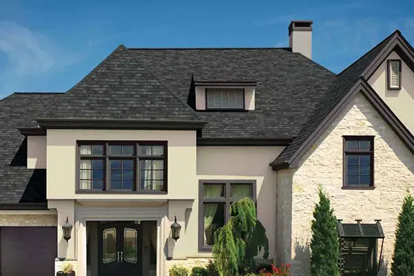 Beige home with black shingle roof
